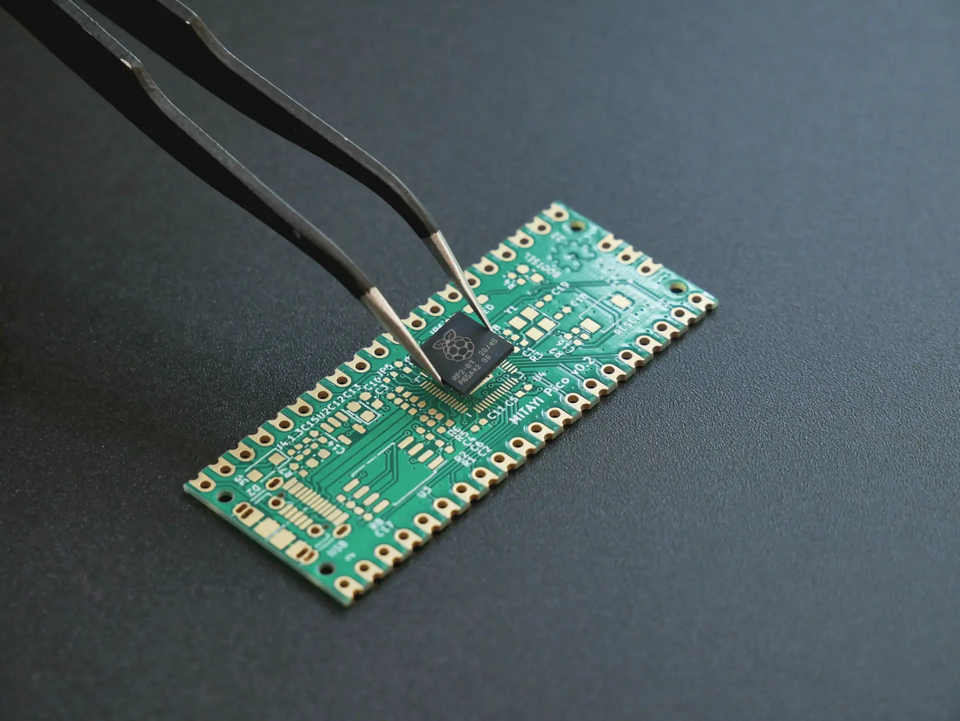 Tweezers placing a microchip onto a circuit board
