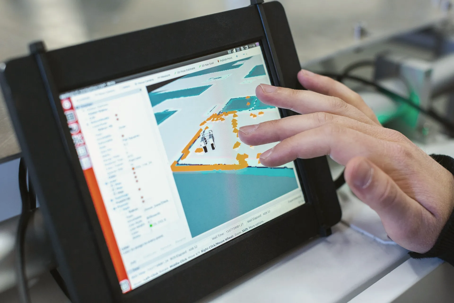 Hand using an industrial touchscreen running live production software